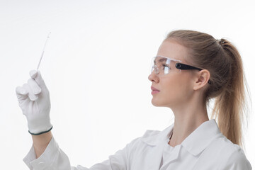 The girl laboratory assistant shows an indicator tube with the result of the analysis. Laboratory assistant in a medical laboratory or a petroleum product quality laboratory