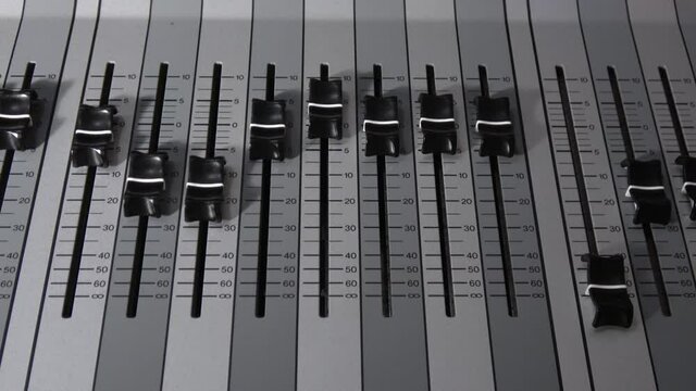 Motorized digital music console faders.