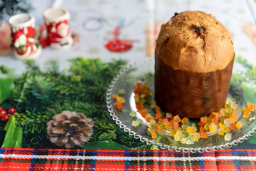 Panettone decorated with candied fruits on the table for Christmas day.