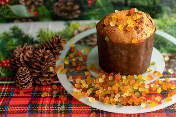 Panettone decorated with candied fruits on the table for Christmas day.