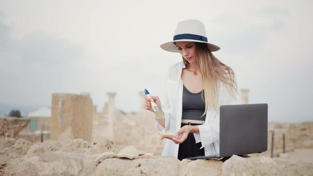 Experienced archeologist using wireless laptop while digging ruins of ancient temple. Expedition for researching old civilisation and architecture.