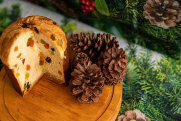 Panettone cut with candied fruit on the Christmas dinner table, top view
