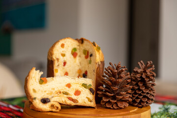 Panettone cut with candied fruit on the Christmas dinner table, approximate photo