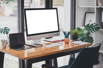 modern office with blank screen tablet and office equipment on the table