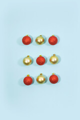Abstract flat lay stock image of yellow gold  and red glitter Christmas balls on a blue background, isolated, top view. Christmas concept.