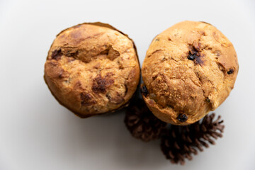 Panettones on white table, Christmas cones on the side, light background, photo seen from above