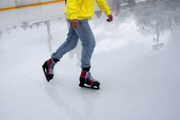 Closeup of feet of man with ice skates on an ice rink