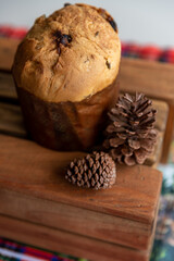 Italian panettone with pine cones on the side, on a wooden box, Christmas decoration, photo seen from above.