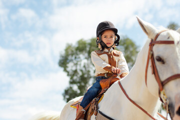 A cute cowgirl ridding a horse in a ranch