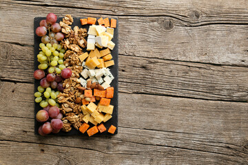 Cheese plate with variety of appetizers on table