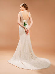 Bridesmaid's ivory gown. Beautiful bride in mermaid wedding dress with white rose in her hands....