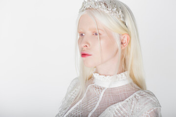 Pretty albino woman in crown with pearls and gems isolated on white.