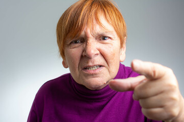 Senior beautiful woman standing over isolated grey background pointing displeased and frustrated to the camera, angry and furious with you