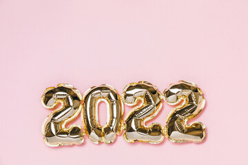 New year 2022 balloon celebration card. Gold foil helium balloon number 2022 isolated on pink background. Flat lay, merry christmas, happy holidays mockup.