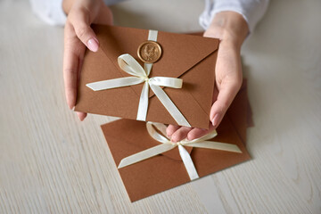 Gift Certificate, gift voucher or discount in woman hand. two invitation envelope with ribbon and...