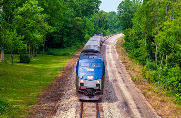 Amtrak passenger train traveling from Chicago, Illinois to Detroit, Michigan through verdant...