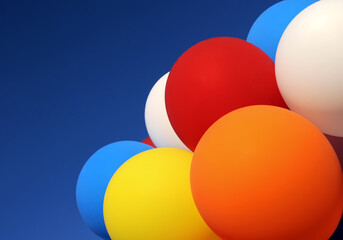 multicolored balloons in the city festival on blue sky background