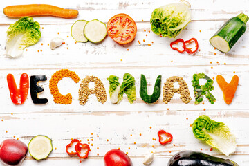Presentation of vegan diet month in january called Veganuary. Flat lay on white rustic wooden background - obrazy, fototapety, plakaty