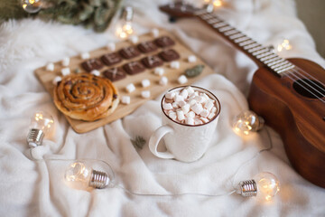 A cup of hot cocoa with marshmallows with christmas decor, pastry and cookies. Cozy ambience at home for christmas. Merry Christmas cookies