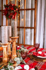 Christmas set table in living room chalet ready for festive Christmas or New Year's festive dinner, red refrigerator, Christmas wreath