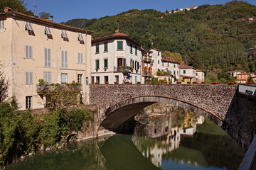 Fototapeta na wymiar Bagni di Lucca, Tuscany, Italy: landscape of the village known for its thermal springs with the ancient bridge, buildings and the Apennine mountain in the background