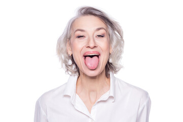 Obraz na płótnie Canvas Shot of a beautiful mature woman having fun and teasing sticking out her tongue isolated on white background