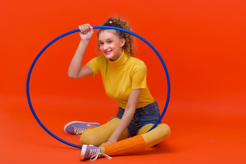 Fitness girl sitting on floor with hula hoop