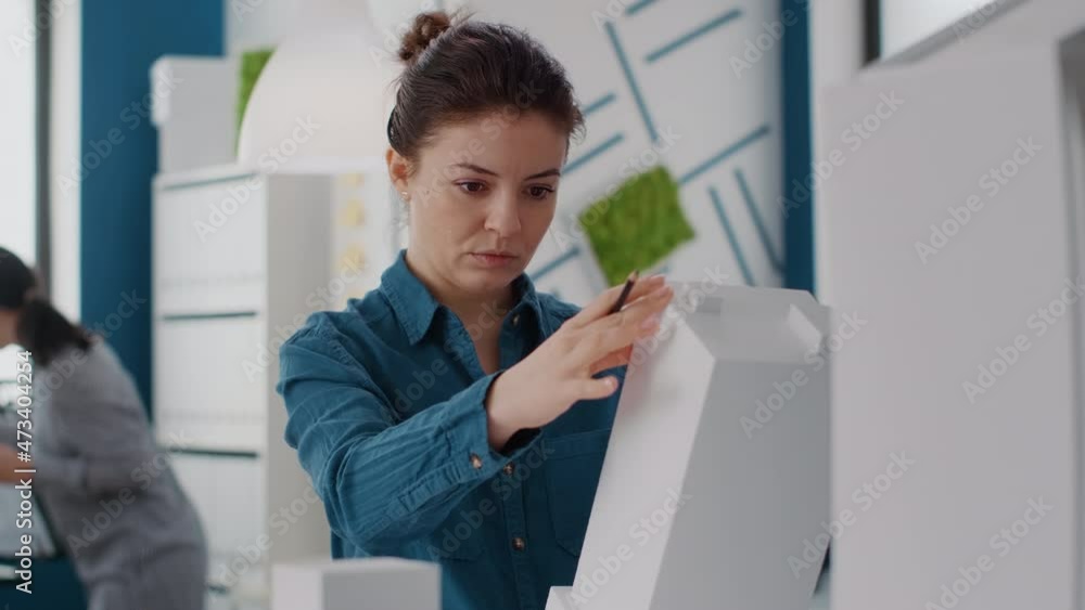 Aufkleber portrait of woman engineer analyzing building model and structure to design construction plan. close
