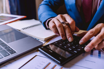 businessman working in the office with using a calculator to calculate the numbers finance...