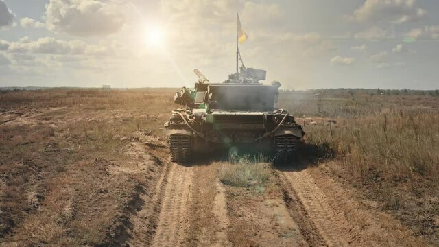 Military tank shooting fire on battlefield. Rocket launchers fire from tank muzzle, back view. Military army tank armored combat on sandy desert road. War fighting vehicle, battle technology concept
