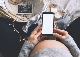 Pregnant woman with smartphone. Closeup pregnant belly with ultrasound photo and medical notes.