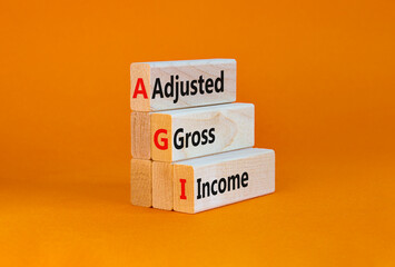 AGI adjusted gross income symbol. Concept words AGI adjusted gross income on wooden blocks....
