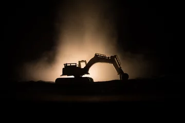 Fotobehang Vrachtwagen Construction site on a city street. A yellow digger excavator parked during the night on a construction site. Industrial concept table decoration on dark foggy toned background.  © zef art