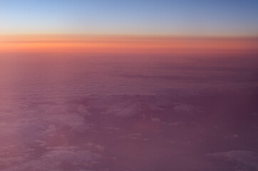 Obraz premium Early sunrise above clouds. Airplane view