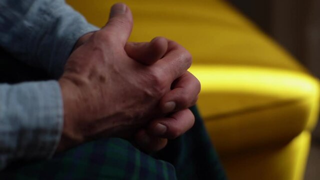 Close-up of unrecognizable senior adult nervous male rubbing hands in trouble and demonstrating stress, anger, irritation. Elderly man talking and gesturing during therapy session with psychologist.