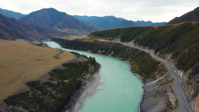 Bird's-eye view of the calm mountain green Katun River. Autumn landscape of the wild nature of the Altai Territory: a huge mountain with trees.