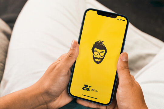 Female hand holding a smartphone with Z&eacute; Delivery de Bebidas app on the screen. Rio de Janeiro, RJ, Brazil. December 2021