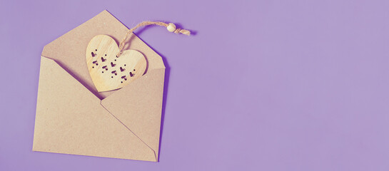 Wooden heart tells from retro craft paper envelope.