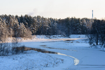 Fototapeta na wymiar beautiful sunset over the river with snowy trees in winter