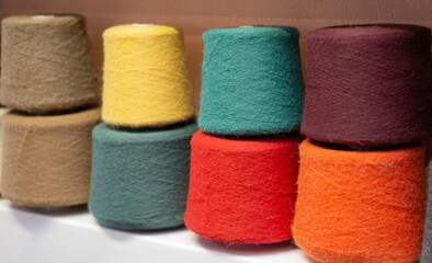 Many multi-colored bobbins of yarn.