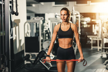 Fototapeta na wymiar Woman Doing Exercise With Resistance Band At The Gym
