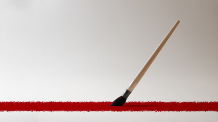 Art brush draws a red line on a white canvas