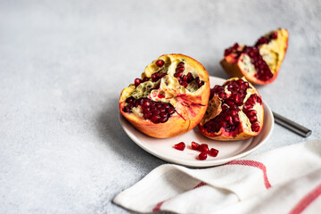 Organic ripe pomegranate on concrete background