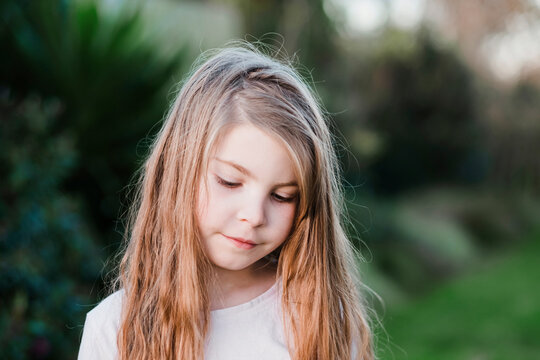 Young girl standing outside and looking down