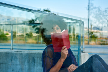 Woman reading a book on a street