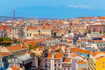Fototapeta na wymiar View to downtown of Lisbon with miltiple colorful houses and bridge of 25 of April over Tagys river, Portugal