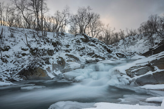 icy waterfall in snow in long expo