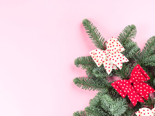 Christmas spruce branch decorated with polka dot bows on pink