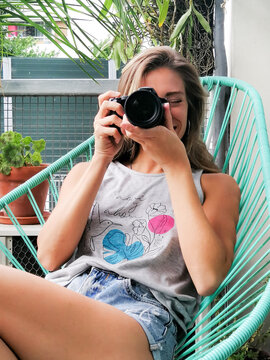 Young woman photographing on a balcony