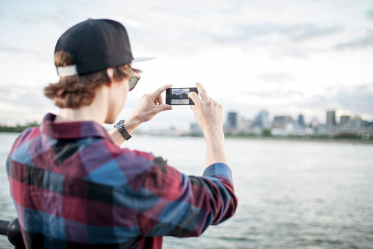 Skateboarder on wharf using smartphone